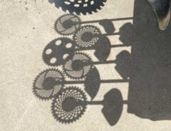 ヒマワリのような影をつくった草刈り機の写真