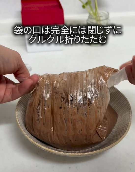 材料の入った袋を折りたたむ様子