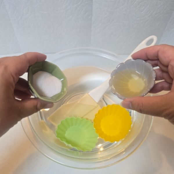 シリコン製品を浸けたお湯の入ったボウルに重曹と酢を入れる様子