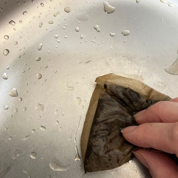 使い終わった麦茶パックでキッチンシンクを磨く様子