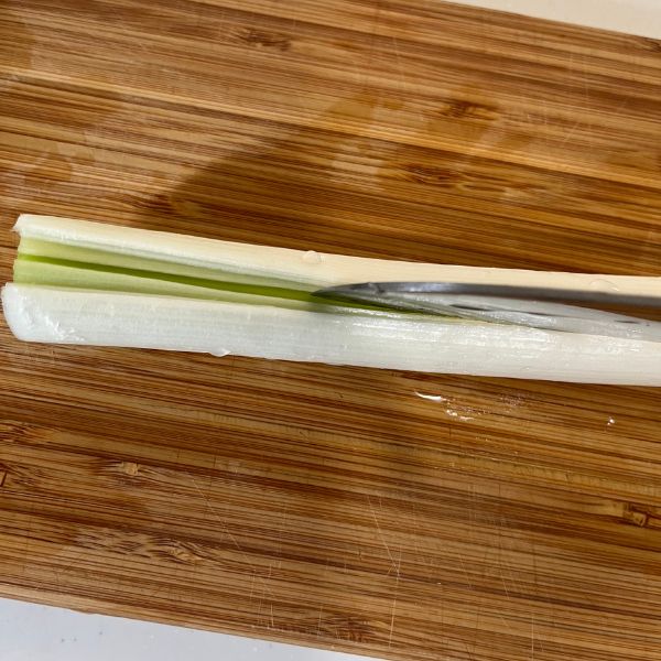 長ネギに包丁で縦に切り込みを入れる様子