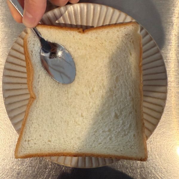 食パンにスプーンの背を押し当てる様子