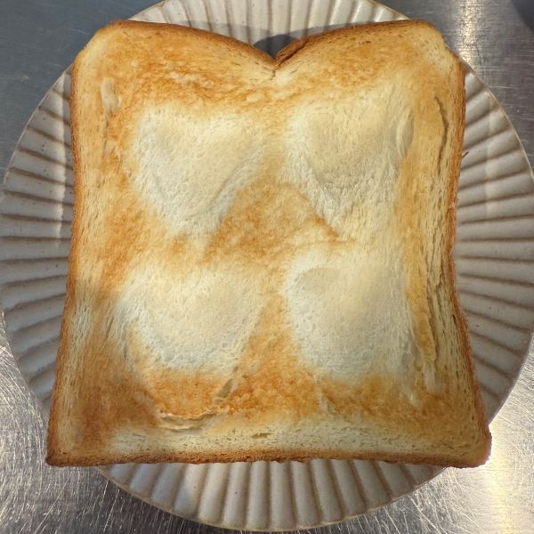 スプーンの背でハート型を付けた食パンを焼いた様子