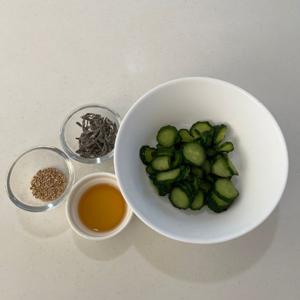 小皿に入れたごま油と塩昆布とゴマと水分を絞ったキュウリを並べた様子