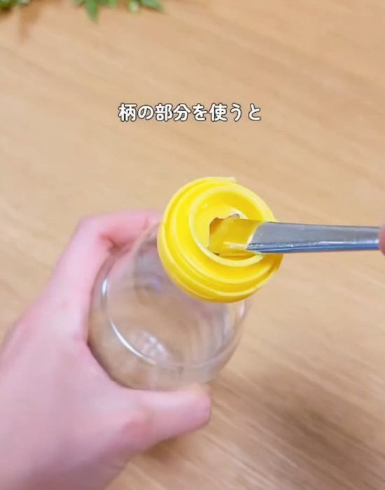 スプーンの柄を蓋に差し込む様子
