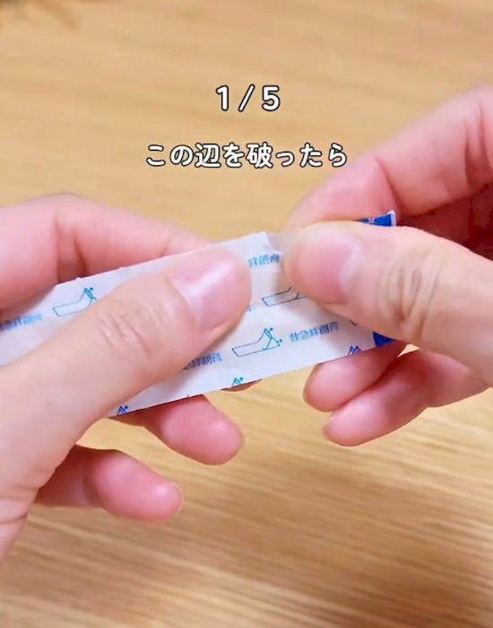 絆創膏の袋を破いている様子
