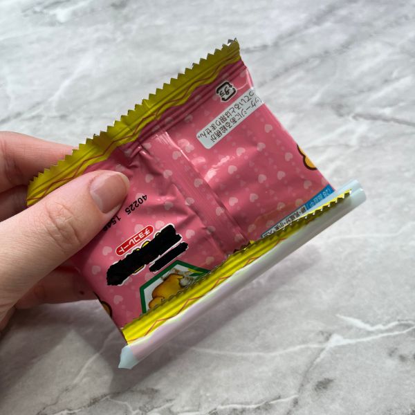 ストローで封をしたお菓子の袋を逆さにして持つ様子