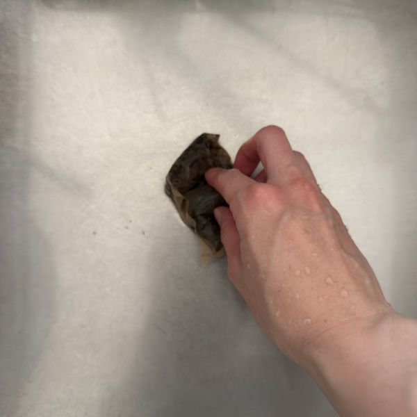 使い終わった麦茶パックでシンクをこする様子