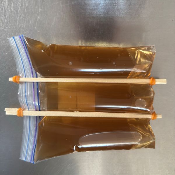 麦茶を入れたチャック付き保存袋を割り箸で挟んで両端を輪ゴムで固定した様子