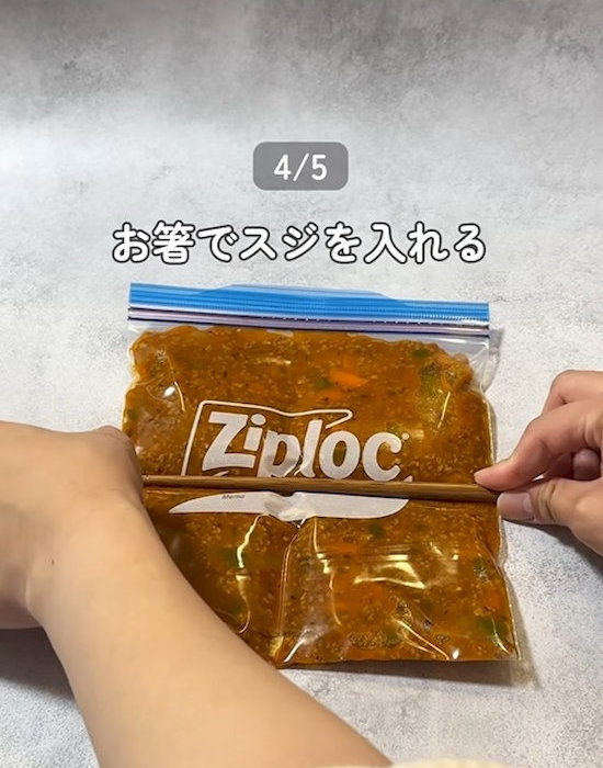 ミートソースの入ったフリーザーバッグにお箸で筋を入れる様子