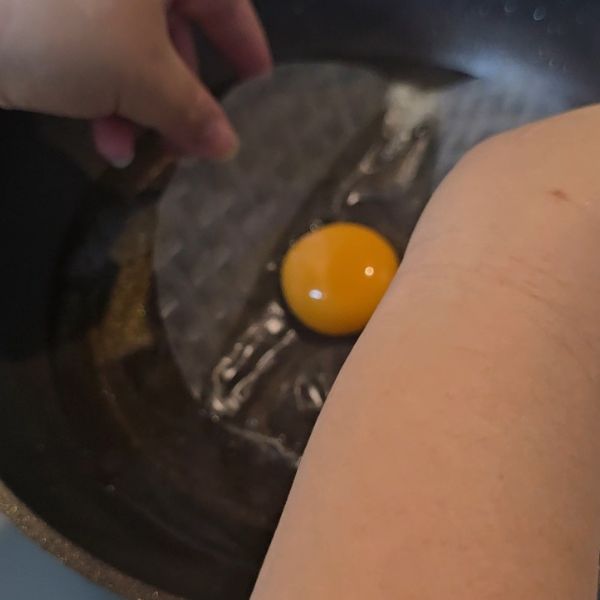 卵黄をのせたライスペーパーを油を入れたフライパンに入れる様子