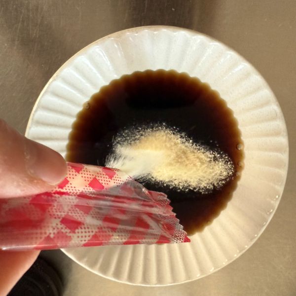 コーヒーを入れた容器に粉ゼラチンを加える様子