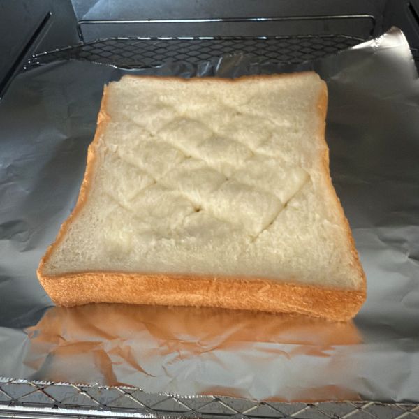 トースターの網の上にアルミホイルを敷いて食パンをのせた様子