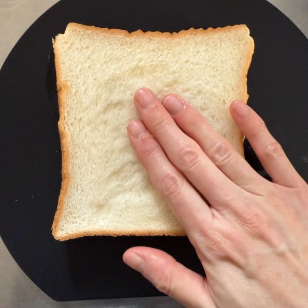 手に付けた水を食パンに付ける様子