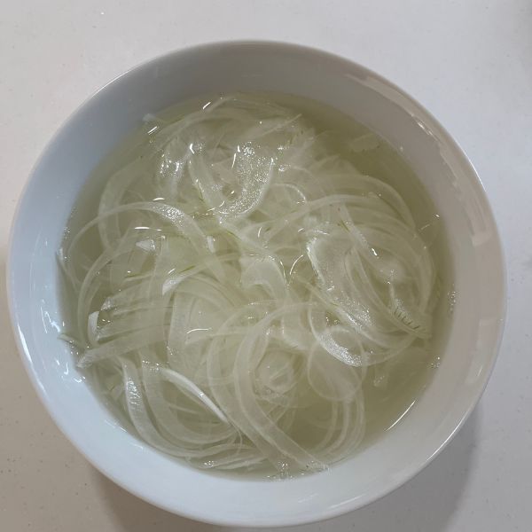 薄切りにしたタマネギをレモン水にさらす様子