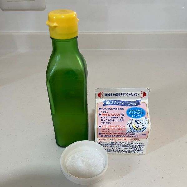 レモン果汁の瓶とパックに入った生クリームと砂糖を並べた写真