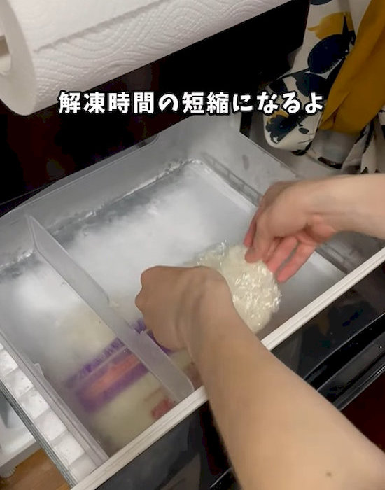 ラップに包んだご飯を冷凍庫へ入れる様子