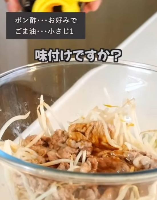 電子レンジで加熱したモヤシと豚こま肉に味付けをしている様子