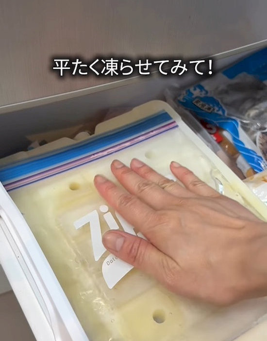 水の入ったフリーザーバッグを冷凍庫に入れている様子