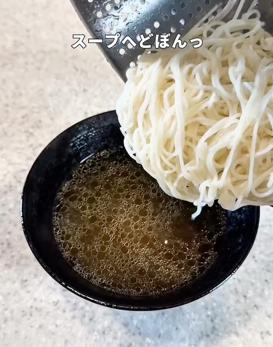 スープの入った器にそうめんを入れる様子