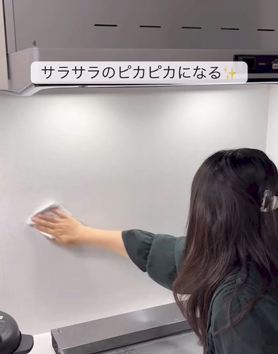 キッチンの壁を拭く女性