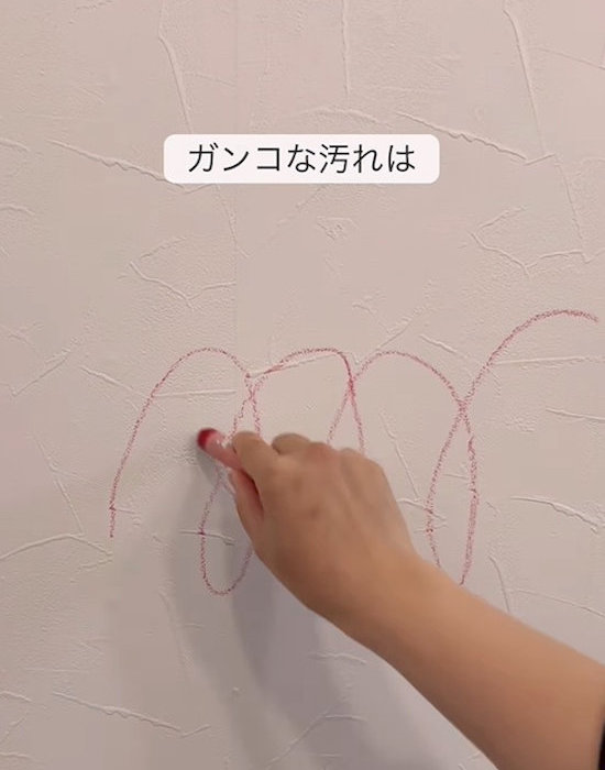 壁にクレヨンで落書きする様子