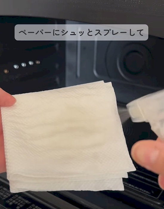 重曹スプレーをキッチンペーパーに吹き付ける様子