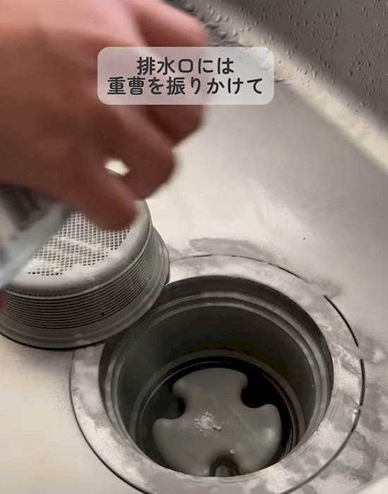 排水口に重曹を振りかける様子