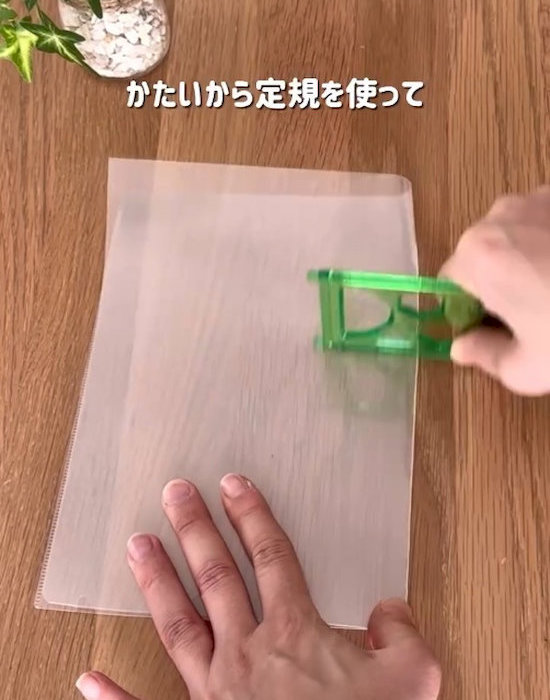 クリアファイルを定規で折っている様子