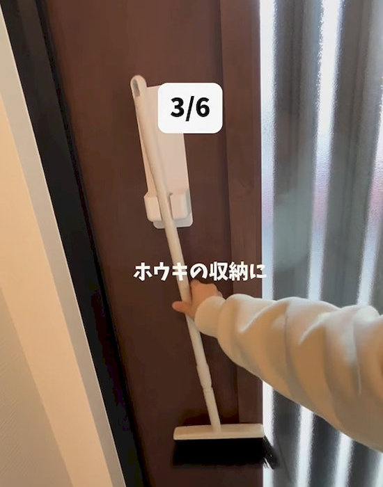 『シャワーホルダー（バス用、マグネット）』でほうきを収納している様子