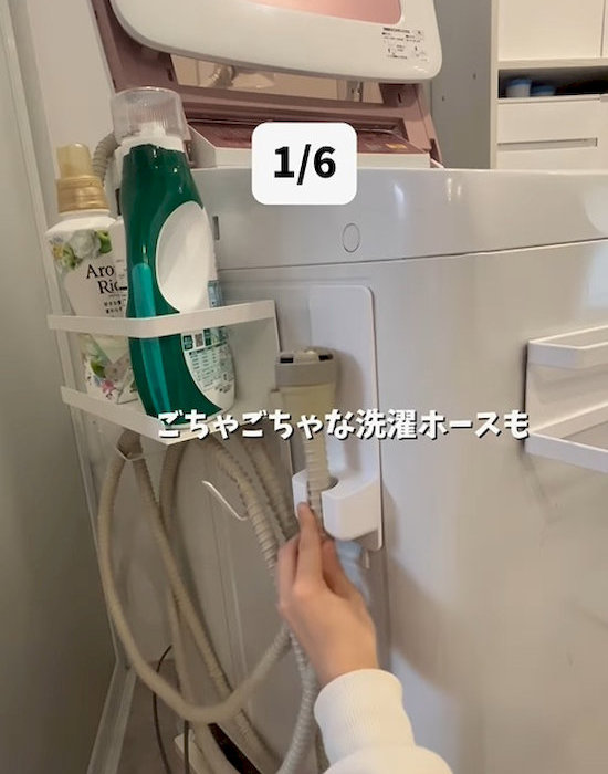『シャワーホルダー（バス用、マグネット）』で洗濯ホースを収納している様子