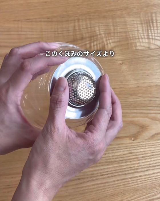 プラスチック容器の底の部分に排水口を当てている様子