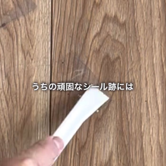 シール跡をヘラでこする様子