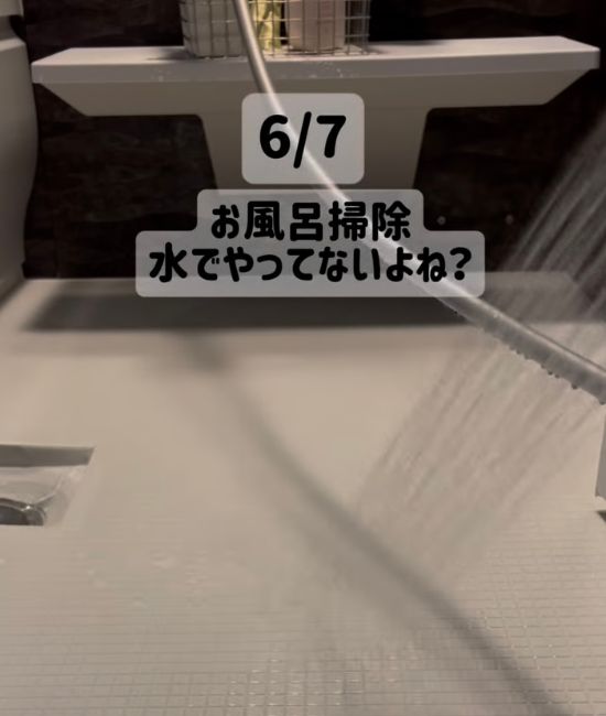 浴室の床にシャワーで水をかける様子