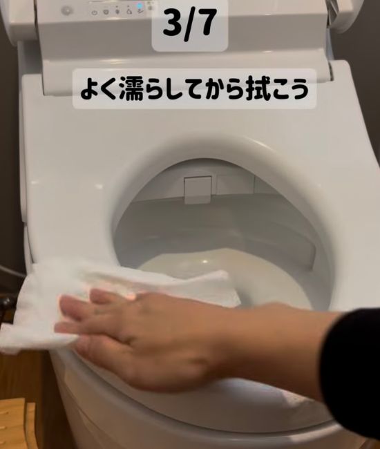 便座を掃除用のシートで拭く様子