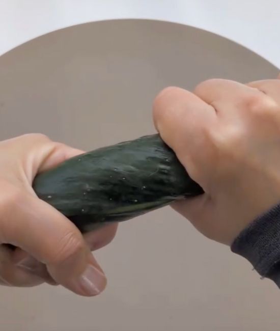 キュウリを両手で持ってひねる様子