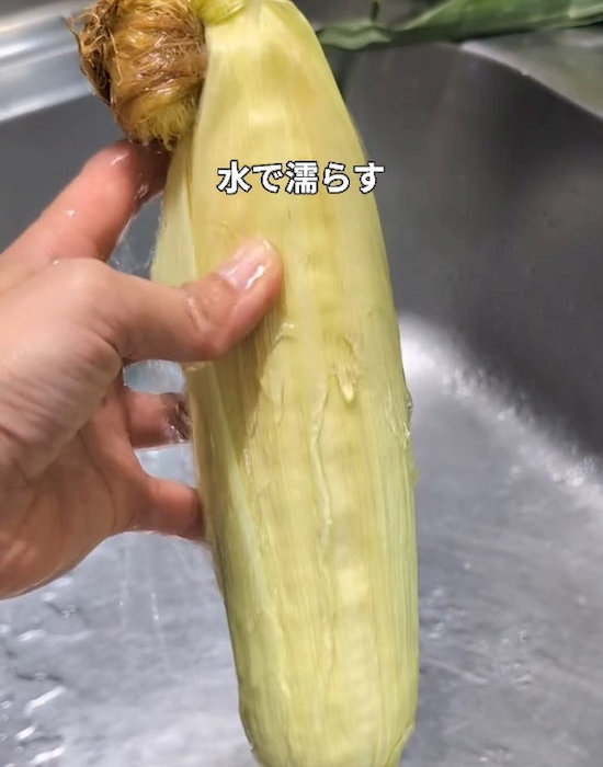 薄皮の残ったトウモロコシを水で濡らしている様子