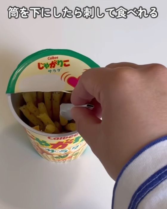 『じゃがりこ』の蓋で作った円錐状の持ち手で『じゃがりこ』をつまむ様子