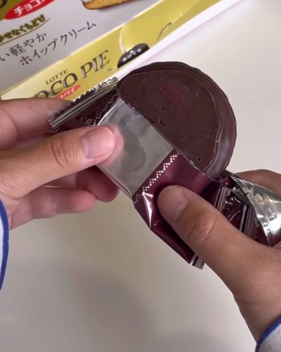 個包装の袋を半分開けて『チョコパイ』を取り出した様子