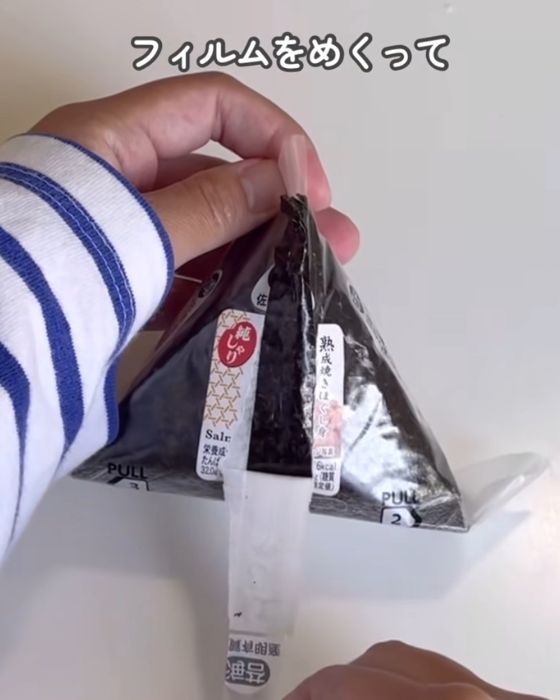 おにぎりのフィルムを中央から縦に引いた様子