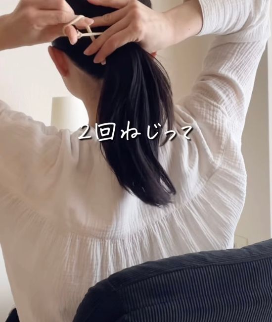 髪を束ねる前にゴムをねじる様子