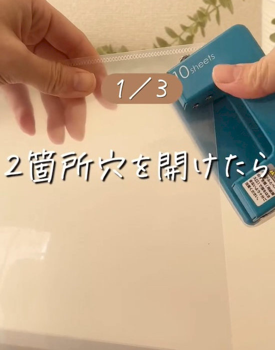クリアファイルに穴開けパンチで穴を開ける様子