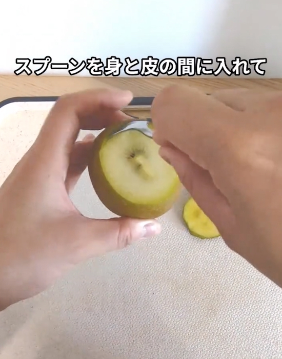 キウイの皮と実の間にスプーンを差し込む様子