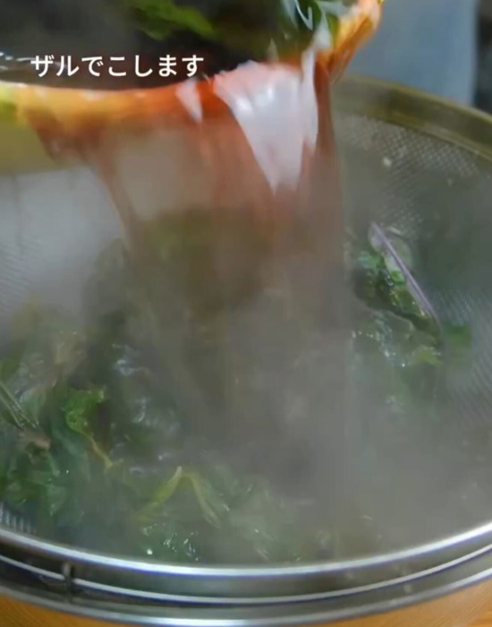ゆでた赤シソをザルでこしている様子