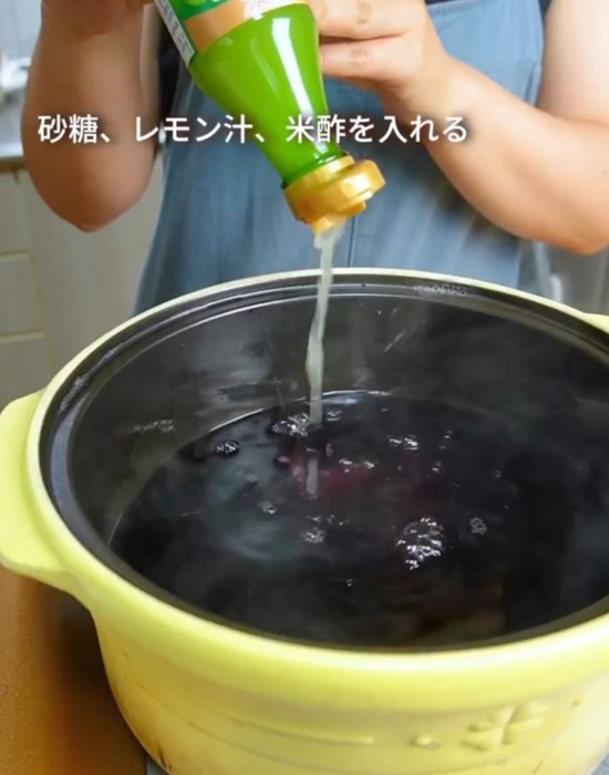 赤シソで作った液体にレモン汁を加えている様子