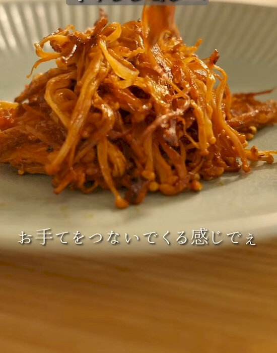 完成したエノキのトマトソース炒め煮を皿に盛り付けている様子