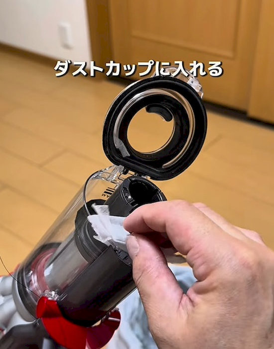 カットしたフローリングシートを掃除機のダストカップに入れている様子