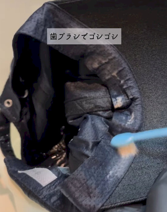歯ブラシで帽子をきれいにしている様子