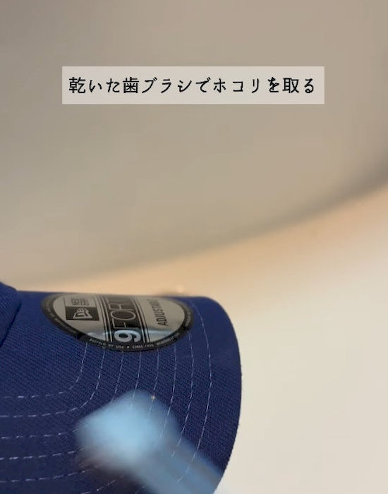 帽子のホコリを歯ブラシで取り除いている様子