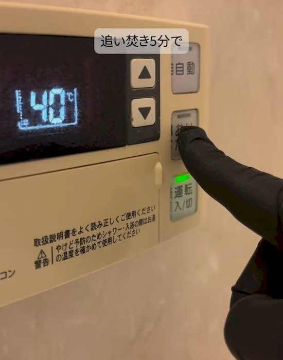 追い焚きボタンを押す様子